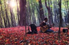 Daniel Goldberg playing guitar in woods